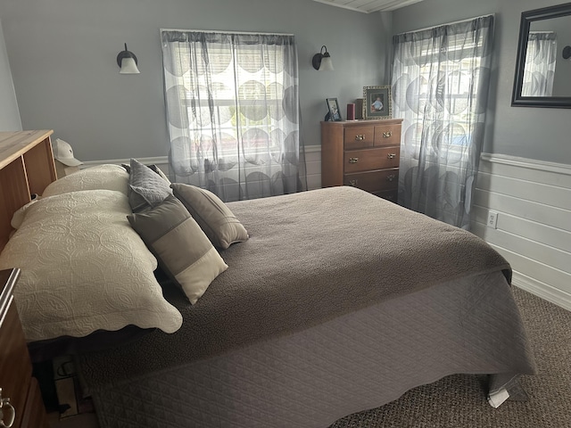 bedroom featuring wainscoting and carpet