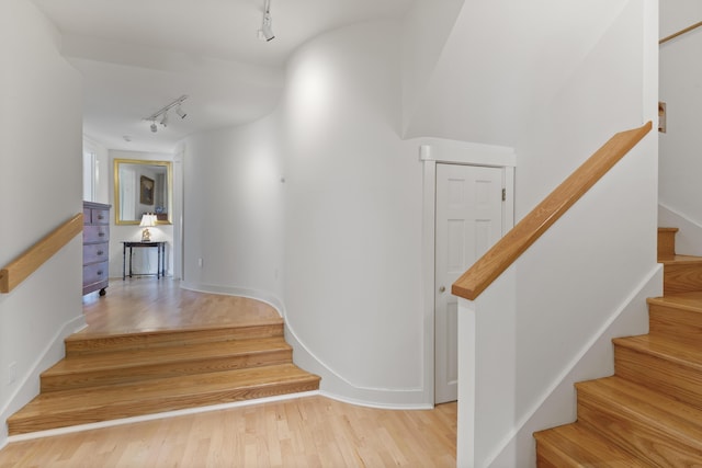 stairs with rail lighting and wood finished floors