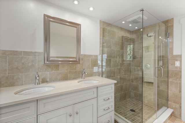 bathroom featuring a sink, a shower stall, and double vanity