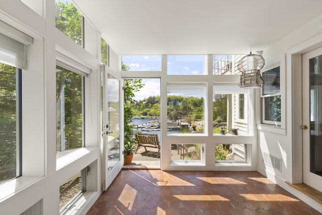 unfurnished sunroom with a water view