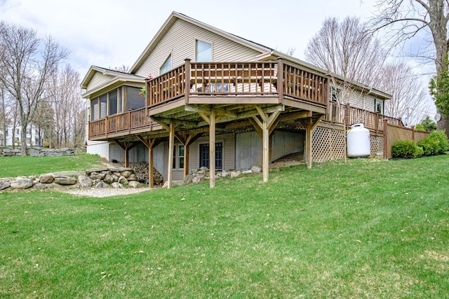 rear view of property featuring a lawn and a wooden deck