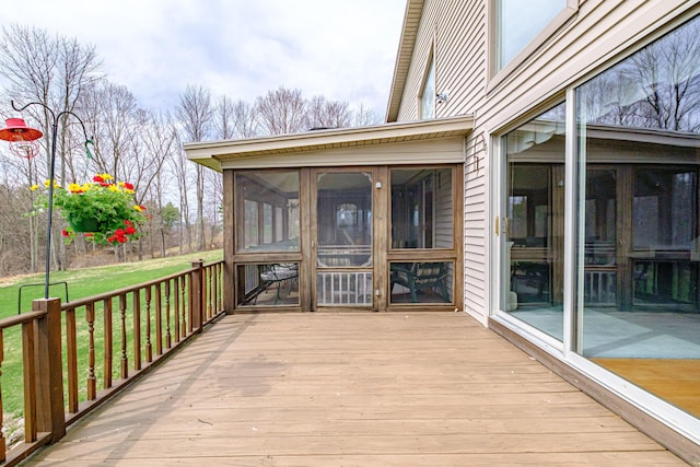 wooden terrace with a lawn and a sunroom