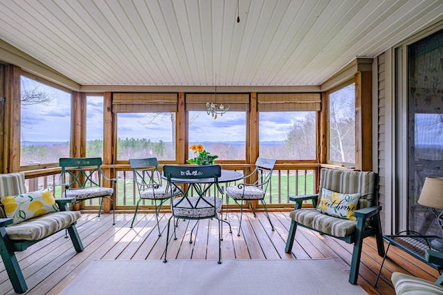 sunroom / solarium with a notable chandelier, wooden ceiling, hardwood / wood-style flooring, and a deck