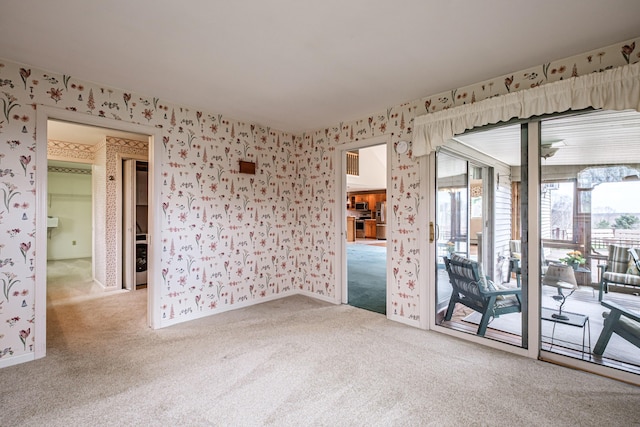 carpeted empty room featuring wallpapered walls