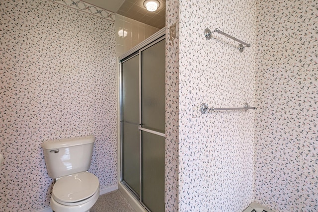 bathroom featuring toilet and a stall shower