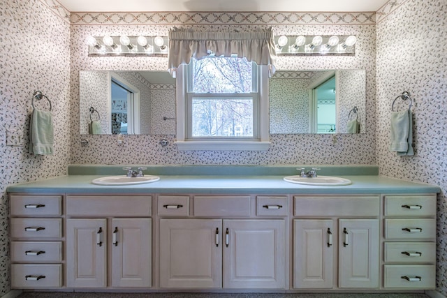bathroom featuring a sink, wallpapered walls, and double vanity