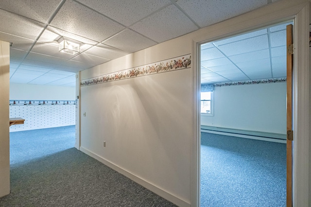 hall featuring carpet floors, a drop ceiling, and a baseboard radiator