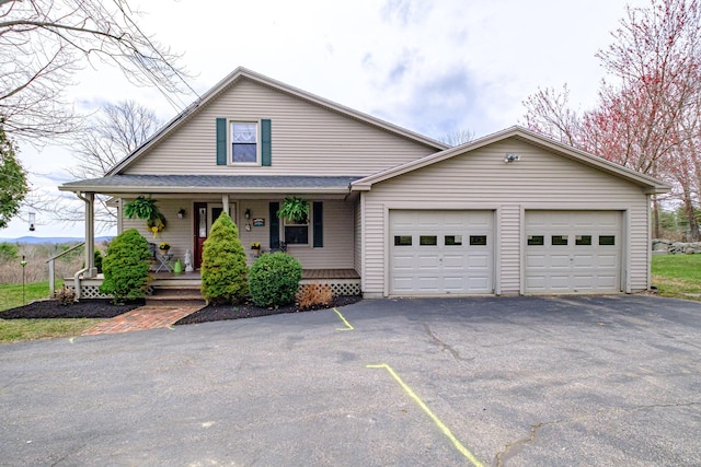 view of front of property featuring an attached garage, aphalt driveway, and covered porch