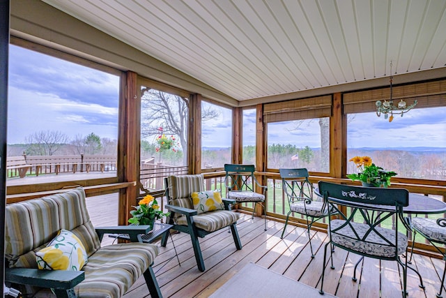 sunroom featuring a chandelier, a wooden deck, and hardwood / wood-style flooring