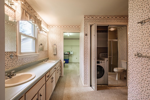 full bath with double vanity, wallpapered walls, washer / dryer, and a sink