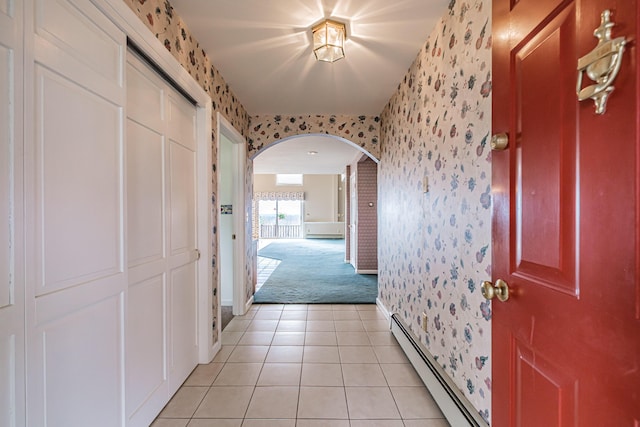 hall with light carpet, arched walkways, wallpapered walls, baseboards, and a baseboard radiator