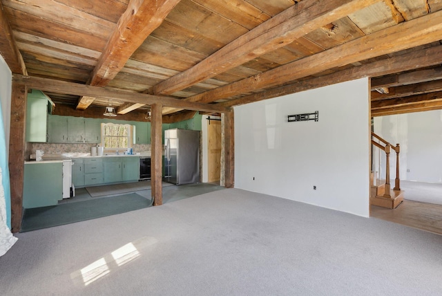 unfurnished living room with beamed ceiling, stairway, light colored carpet, wooden ceiling, and a sink