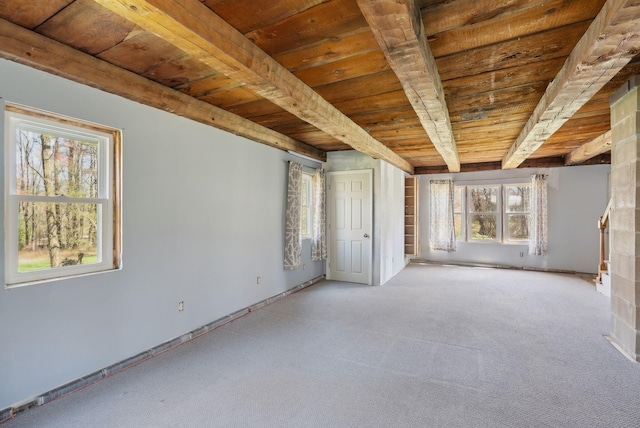 unfurnished bedroom featuring wood ceiling, baseboards, light carpet, and beam ceiling