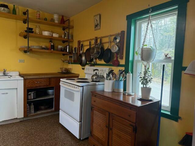 kitchen with brown cabinets, a sink, and electric stove
