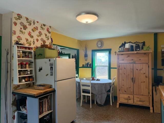 kitchen with open shelves and freestanding refrigerator