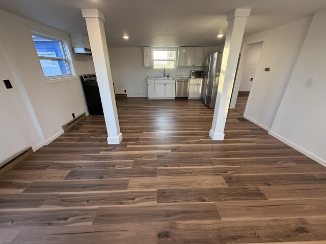 94 Dexter Rd, Corinna, ME 04928 - interior space with a sink, baseboards, decorative columns, and dark wood-type flooring