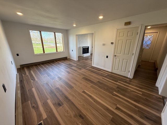 94 Dexter Rd, Corinna, ME 04928 - unfurnished living room with a brick fireplace, recessed lighting, and dark wood-style floors
