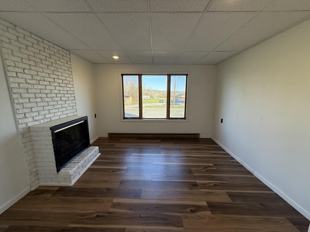 94 Dexter Rd, Corinna, ME 04928 - unfurnished living room with dark wood-style flooring, a fireplace, baseboards, a baseboard heating unit, and recessed lighting