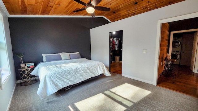 bedroom with baseboards, stacked washer / drying machine, wood ceiling, and lofted ceiling