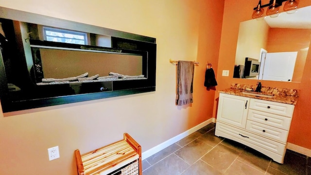 bathroom featuring baseboards, tile patterned floors, and vanity