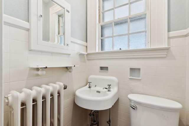 382 College St, Lewiston, ME 04240 - bathroom featuring radiator, a wainscoted wall, a wealth of natural light, and tile walls