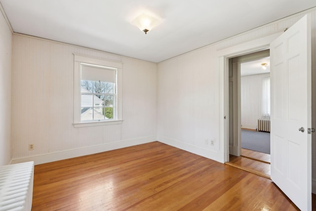 382 College St, Lewiston, ME 04240 - empty room featuring radiator heating unit, baseboards, and light wood-style floors