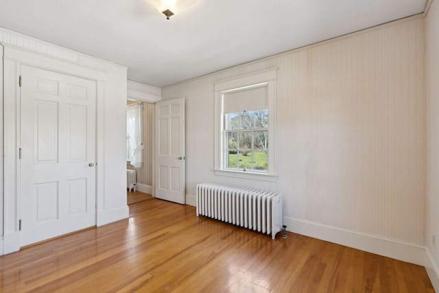 382 College St, Lewiston, ME 04240 - unfurnished bedroom with baseboards, radiator, and light wood finished floors