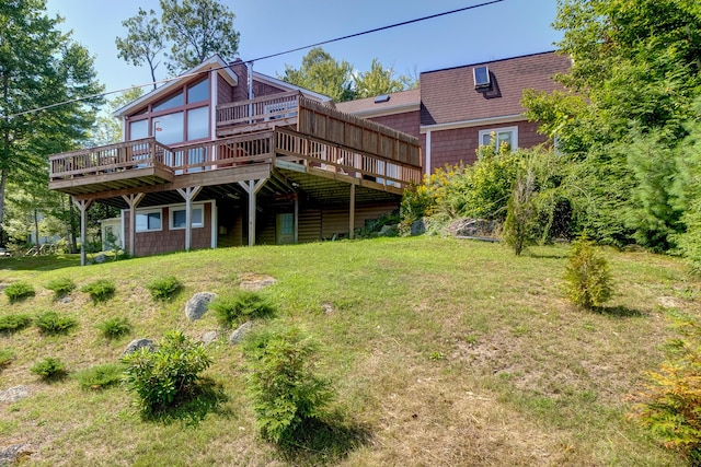 back of house with a lawn, a shingled roof, and a deck
