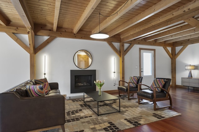 living area with beam ceiling, wood finished floors, and a fireplace