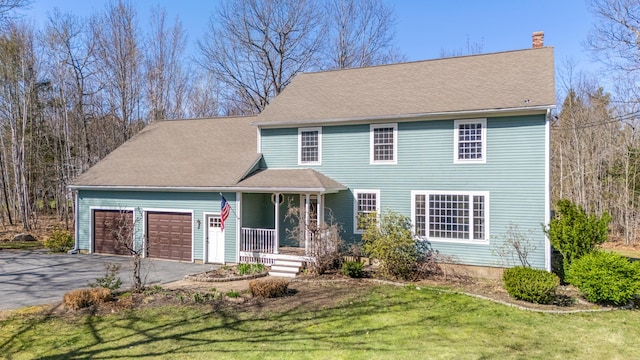 view of front facade featuring a garage, a front lawn, aphalt driveway, covered porch, and a chimney