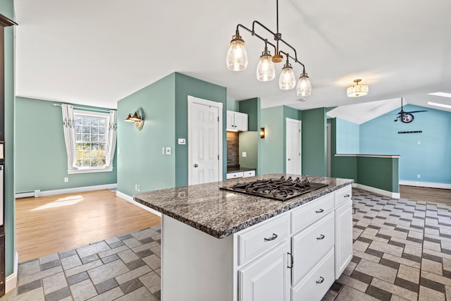 kitchen with white cabinets, stainless steel gas cooktop, baseboards, a baseboard radiator, and a kitchen island
