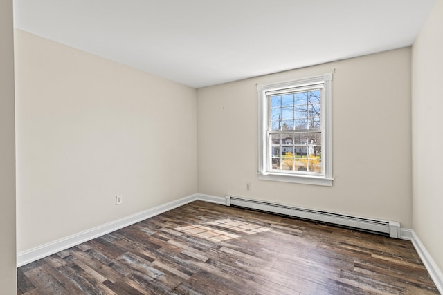 empty room featuring baseboards, a baseboard heating unit, and wood finished floors
