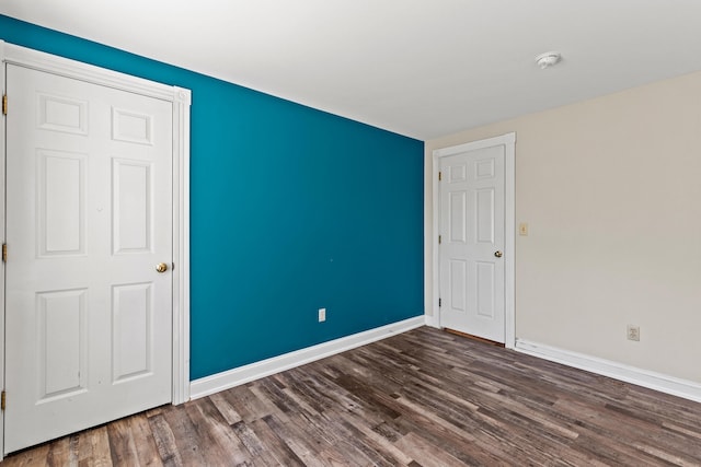 empty room with baseboards and wood finished floors