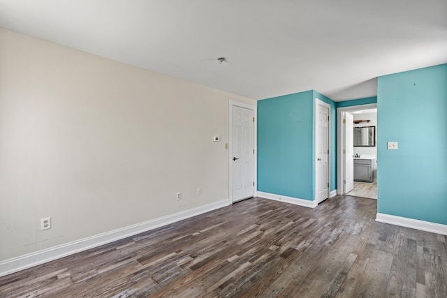empty room with baseboards and dark wood-style floors