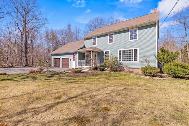 view of front of property with a garage, aphalt driveway, a front yard, and a chimney