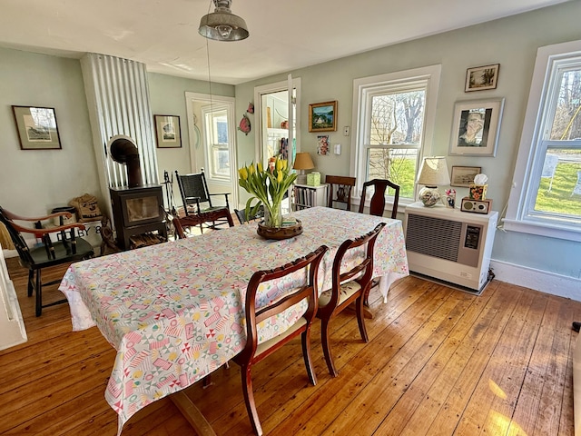7 Mountain St, Vinalhaven, ME 04863 - dining space featuring a wood stove, light wood-style flooring, heating unit, and baseboards