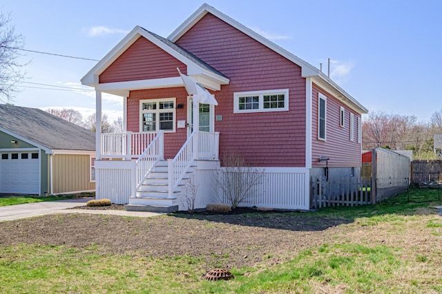bungalow-style home featuring a garage, fence, and a front yard