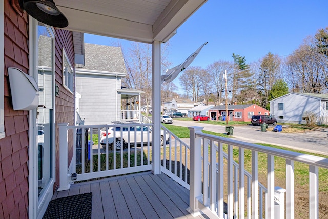 deck featuring covered porch and a residential view