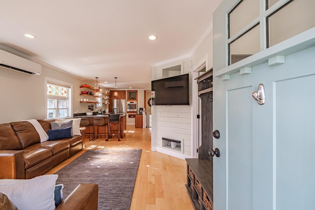 living area with crown molding, a wall mounted AC, recessed lighting, and light wood-style flooring