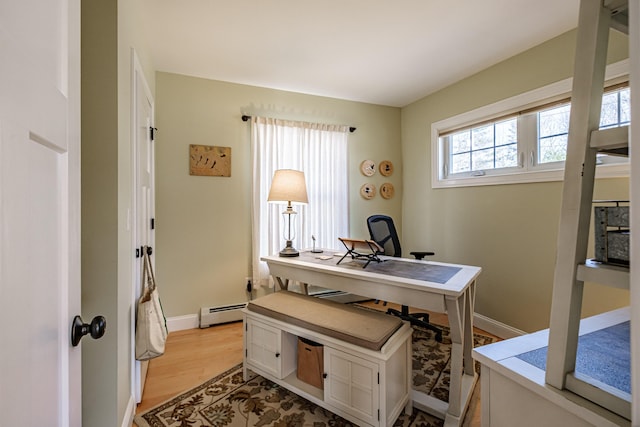 office featuring baseboards, baseboard heating, and light wood-style flooring