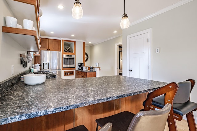 kitchen featuring a breakfast bar area, stainless steel appliances, dark countertops, and a peninsula