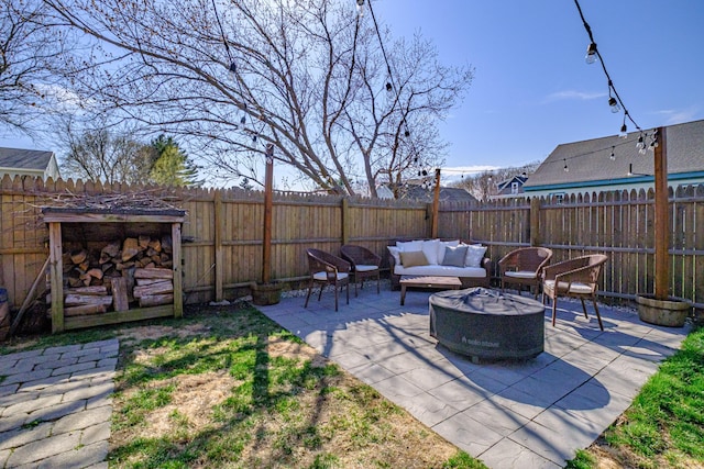 view of patio featuring a fenced backyard and an outdoor living space with a fire pit