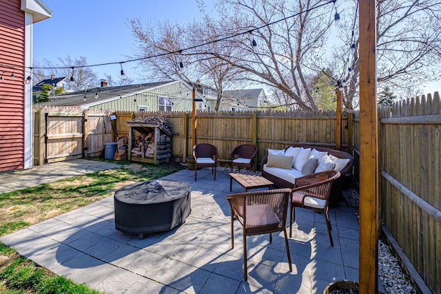 view of patio with a fenced backyard and an outdoor living space with a fire pit