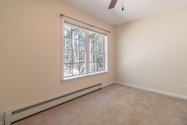 carpeted spare room featuring ceiling fan, a baseboard heating unit, and baseboards