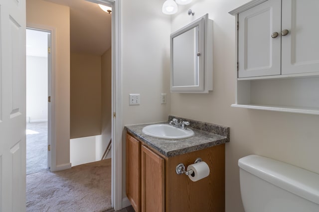 half bath featuring vanity and toilet