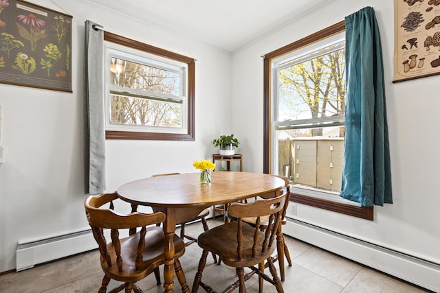 dining room featuring crown molding, a baseboard radiator, and a wealth of natural light