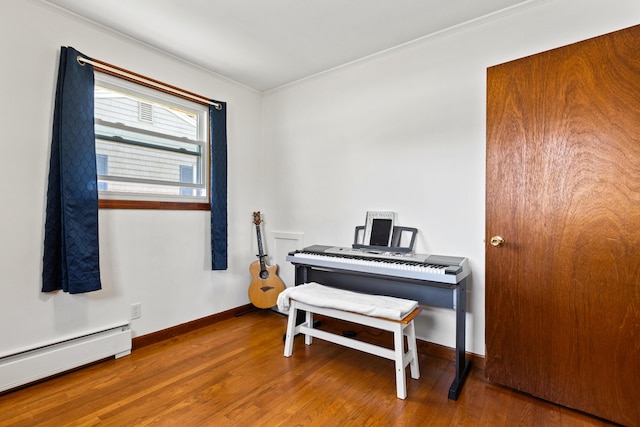 sitting room featuring crown molding, baseboards, wood finished floors, and baseboard heating