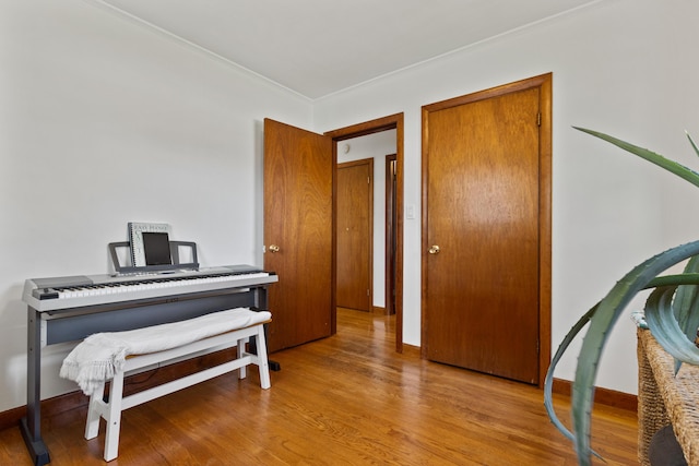 interior space with baseboards, ornamental molding, and wood finished floors