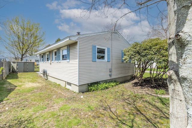 view of home's exterior with a lawn and fence