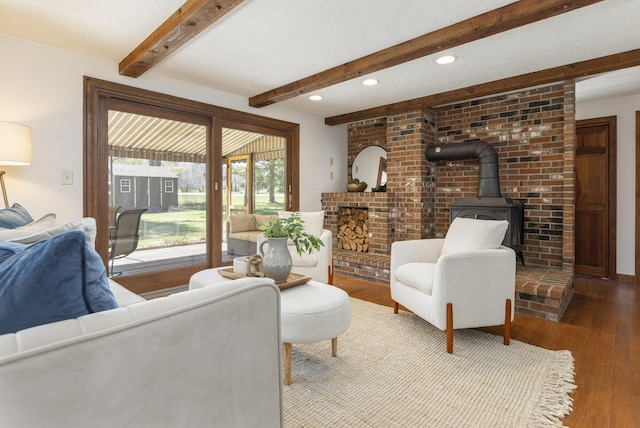 living room featuring a wood stove, recessed lighting, beamed ceiling, and hardwood / wood-style flooring